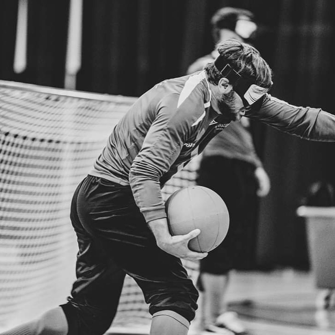 Fatmir Seremeti mitt i ett goalballskott. Bilden är svartvitt.