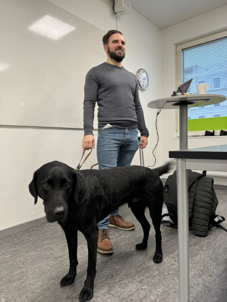 Fatmir och Comet står längst fram i ett klassrum och föreläser.